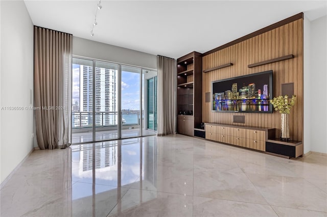 living room with track lighting, a water view, and light tile floors