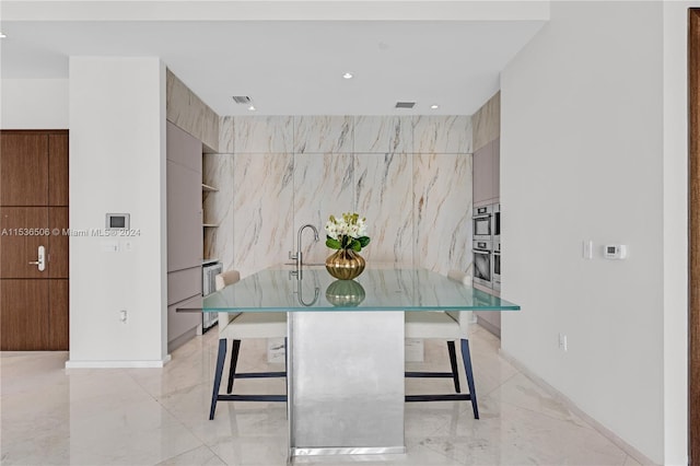 tiled dining area with sink and tile walls