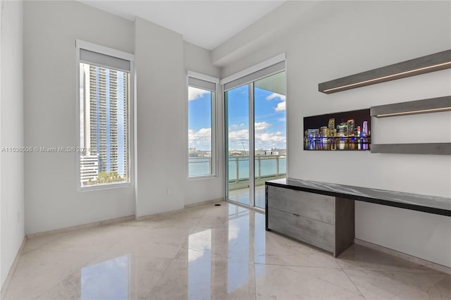 empty room featuring a water view and light tile floors