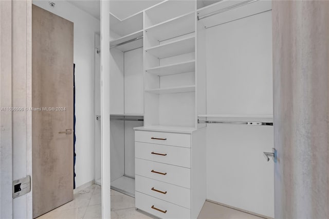 spacious closet featuring light tile floors