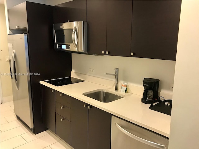 kitchen featuring light tile flooring, stainless steel appliances, and sink