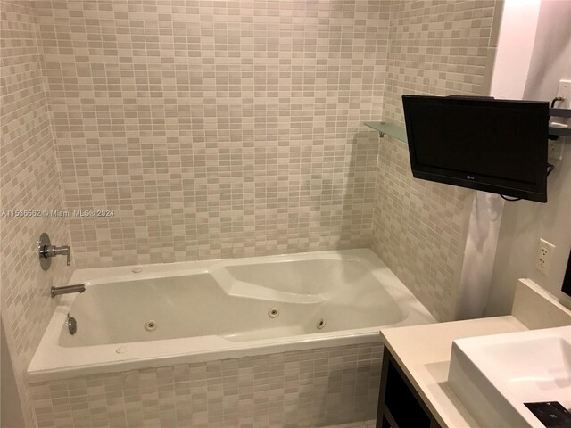 bathroom with tiled shower / bath combo and vanity