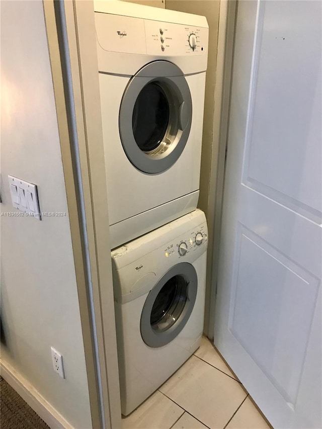 laundry area featuring stacked washer / dryer and light tile floors