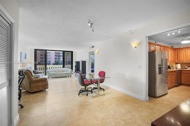 tiled living room featuring a textured ceiling and rail lighting