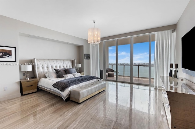 bedroom with an inviting chandelier, access to outside, light hardwood / wood-style flooring, and a water view