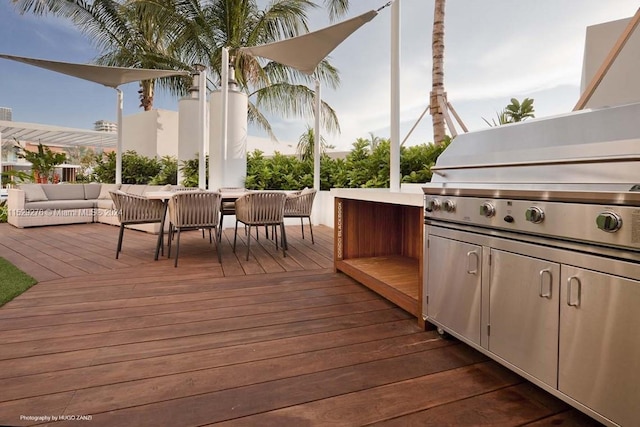 wooden terrace featuring area for grilling and an outdoor living space