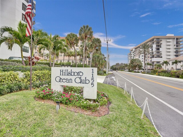 view of community featuring a lawn, a water view, and a beach view