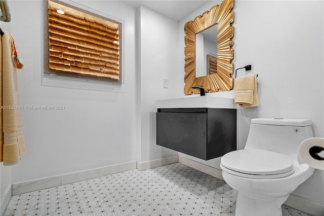 bathroom with tile patterned flooring, vanity, and toilet