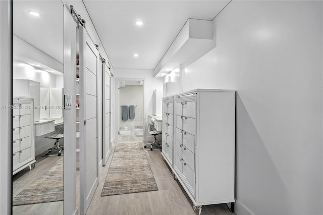 interior space with a barn door and light hardwood / wood-style flooring