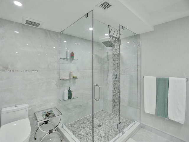 bathroom featuring walk in shower, tile walls, and toilet