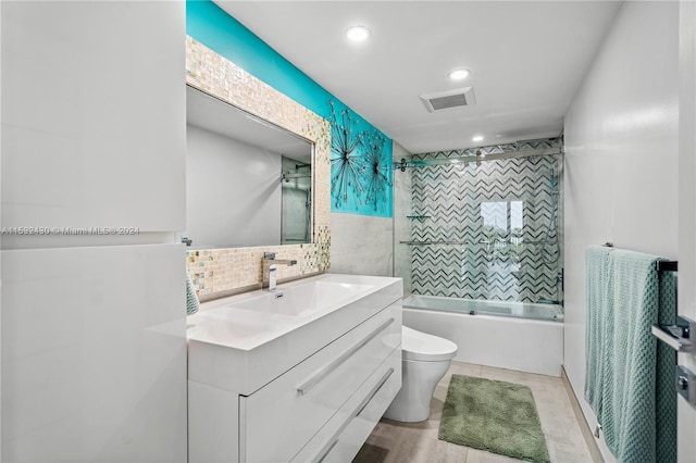 full bathroom featuring vanity, shower / bath combination with glass door, backsplash, toilet, and wood-type flooring