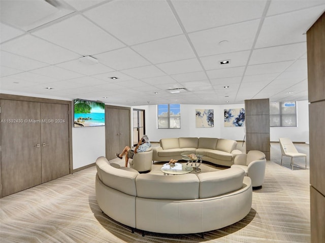 carpeted living room featuring a drop ceiling