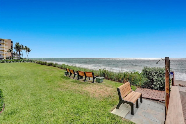 surrounding community featuring a view of the beach, a yard, and a water view