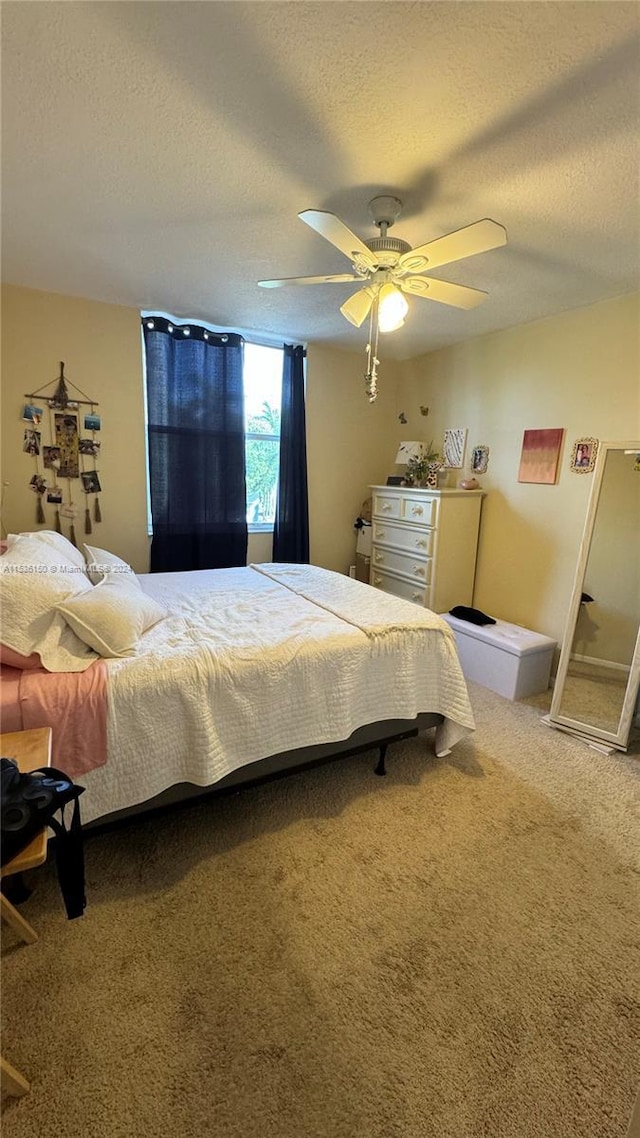 carpeted bedroom with a textured ceiling and ceiling fan