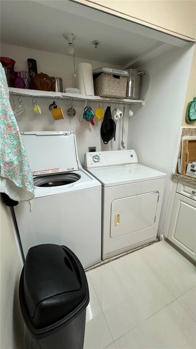 laundry area featuring light tile patterned floors and washing machine and dryer