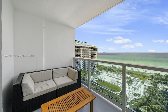 balcony featuring an outdoor living space and a water view