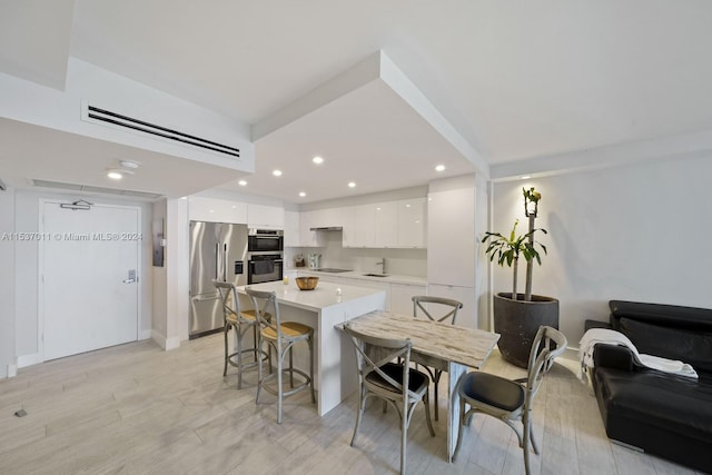 dining area with sink and light wood-type flooring