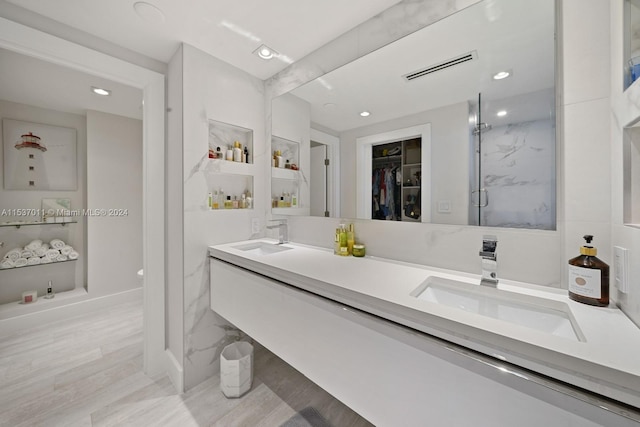 bathroom with dual vanity and wood-type flooring