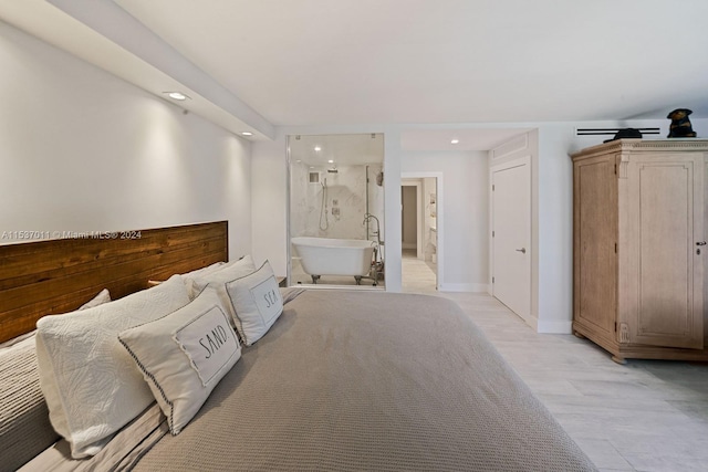 unfurnished bedroom featuring ensuite bath and light hardwood / wood-style floors