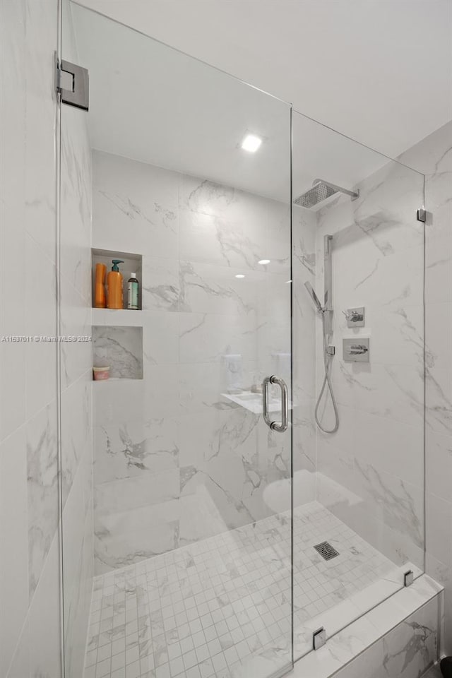 bathroom featuring a shower with door