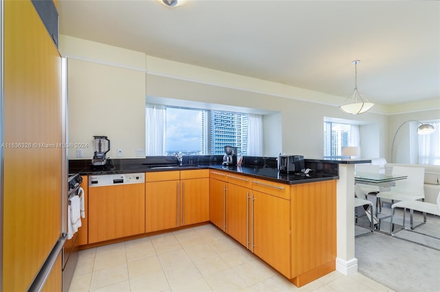 kitchen featuring hanging light fixtures, light tile flooring, sink, and kitchen peninsula