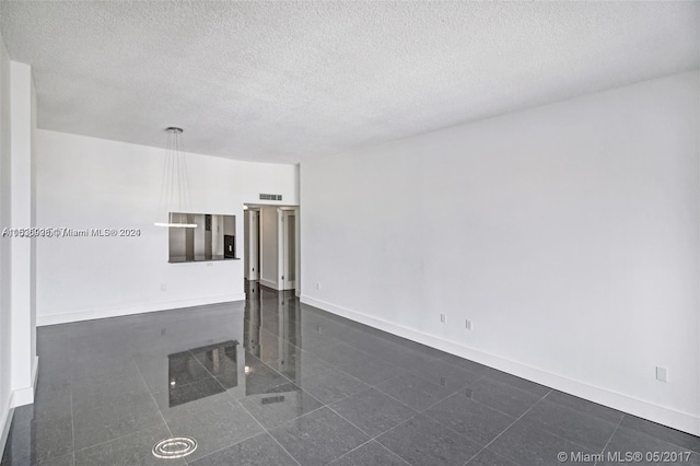 tiled spare room with a textured ceiling