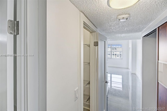 hallway with a textured ceiling