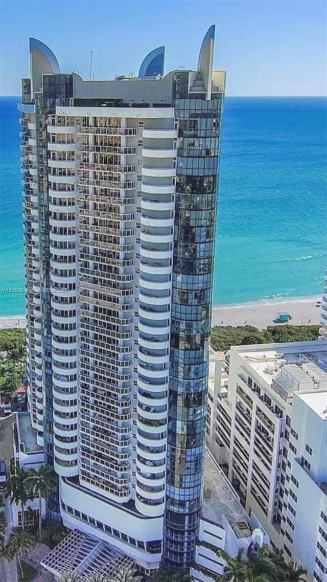 view of property with a water view and a view of the beach