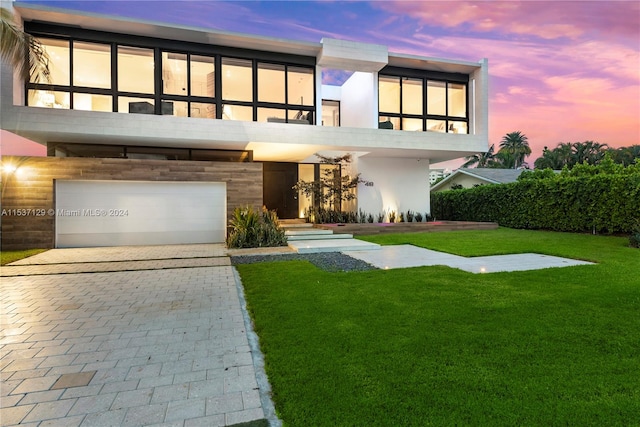 contemporary house featuring a garage and a yard