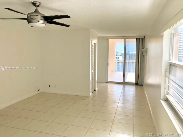 empty room with light tile flooring and ceiling fan