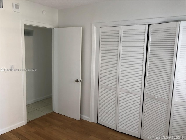 unfurnished bedroom featuring a closet and dark tile flooring