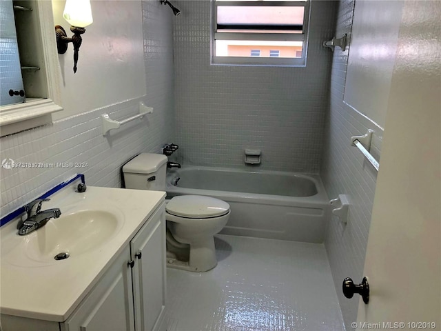 full bathroom with toilet, vanity with extensive cabinet space, tasteful backsplash, tiled shower / bath, and tile walls