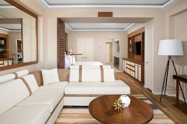 living room with a tray ceiling and light wood-type flooring