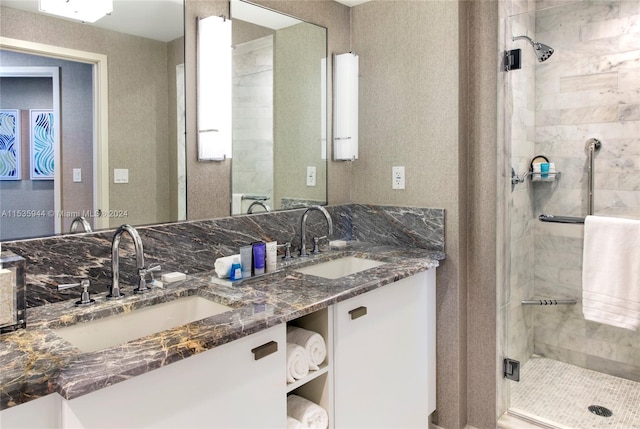 bathroom with double vanity and tiled shower