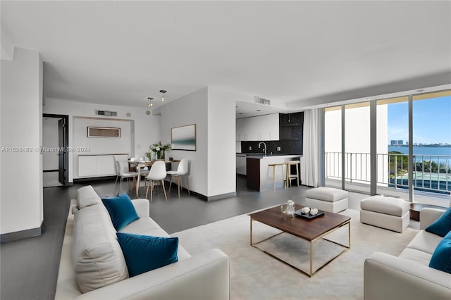 living room featuring a water view and sink