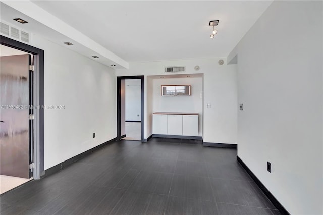 spare room with dark tile flooring