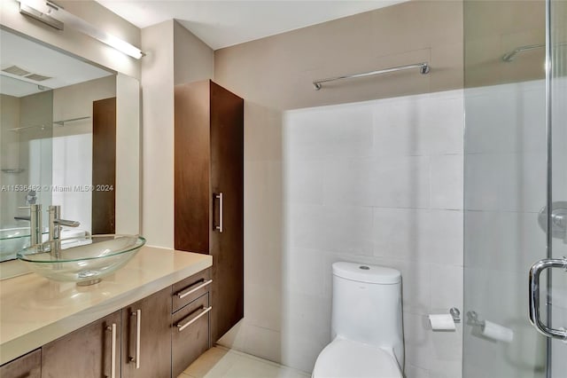 bathroom with vanity, tile flooring, toilet, and tile walls