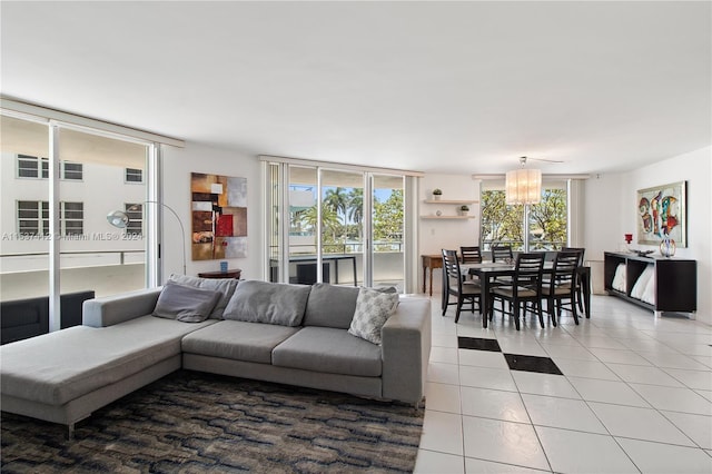 tiled living room with a healthy amount of sunlight and an inviting chandelier