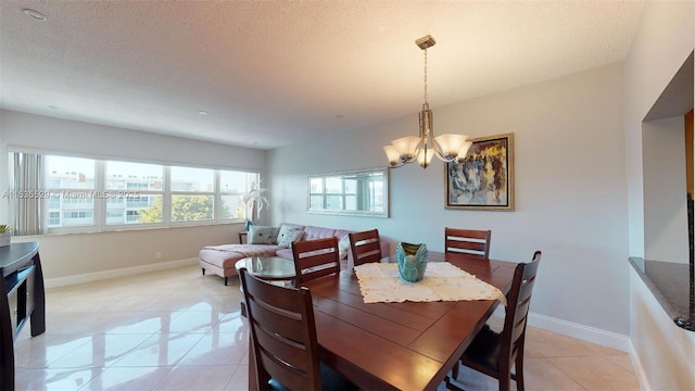 tiled dining space with a notable chandelier and a textured ceiling