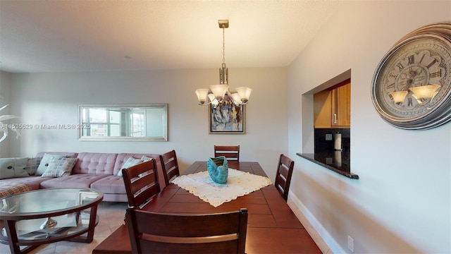 tiled dining room featuring a chandelier