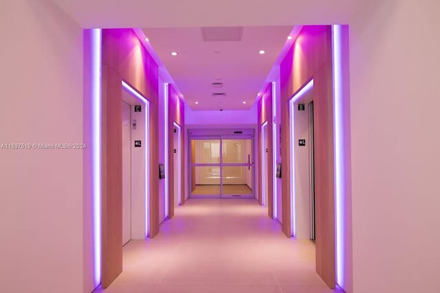 hall with light tile floors and elevator