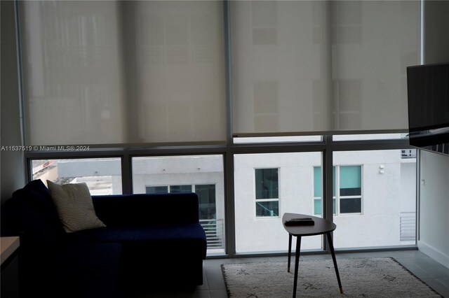 living room featuring dark tile flooring and a healthy amount of sunlight