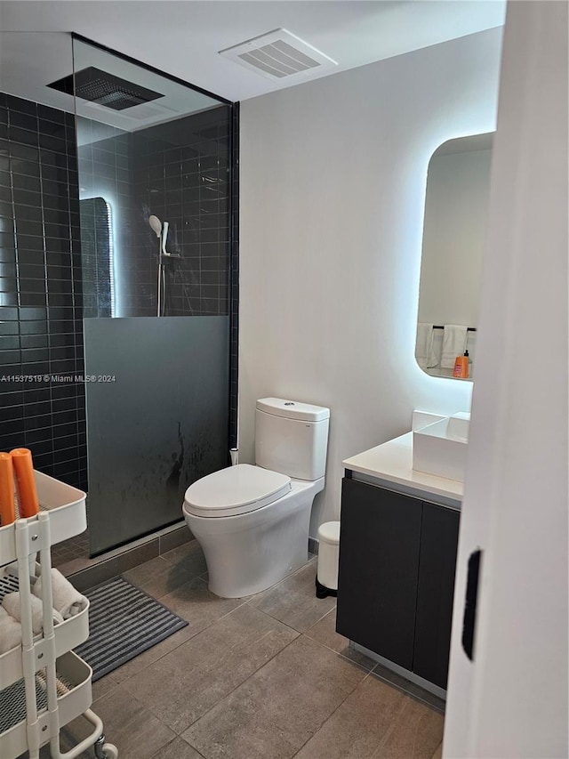 bathroom featuring an enclosed shower, toilet, tile floors, and vanity