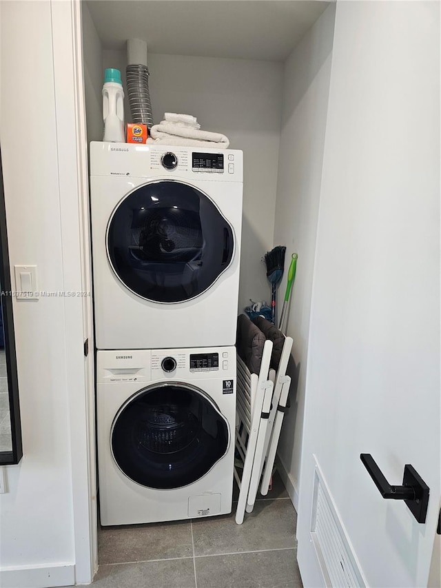 washroom featuring tile flooring and stacked washer / drying machine