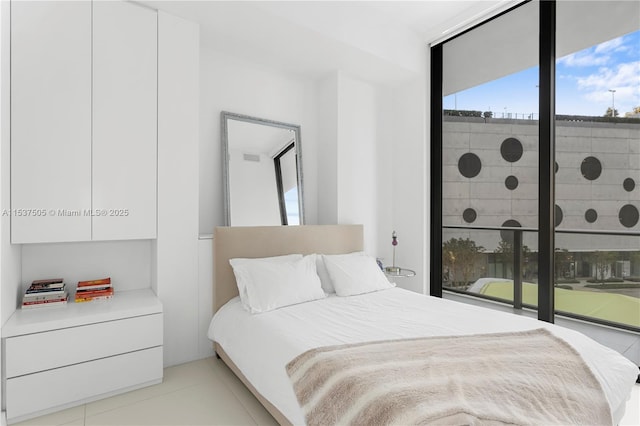 bedroom featuring floor to ceiling windows and light tile patterned flooring