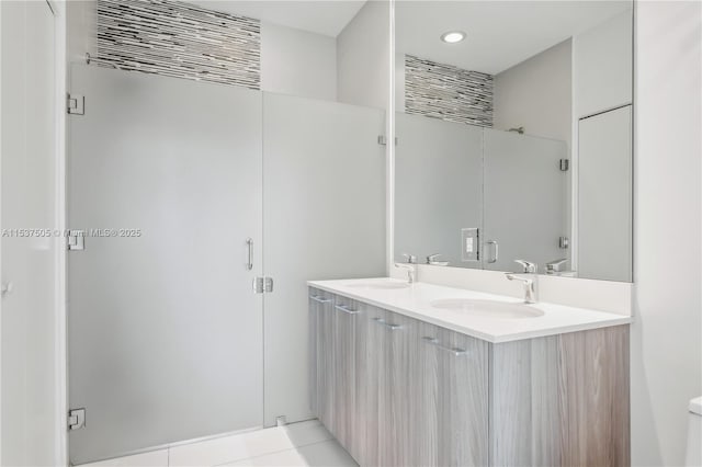 full bath featuring tile patterned flooring, a sink, toilet, and double vanity