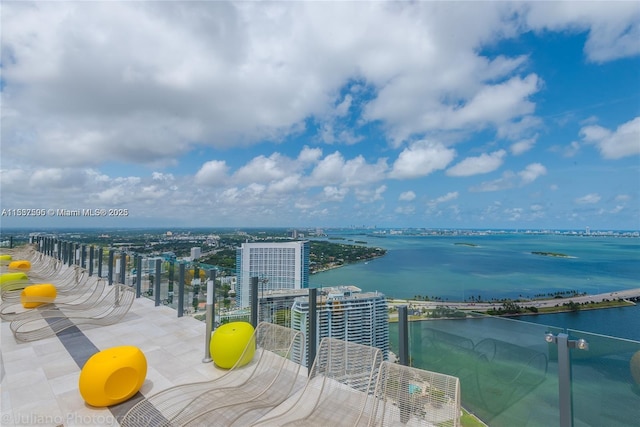 balcony featuring a water view and a city view