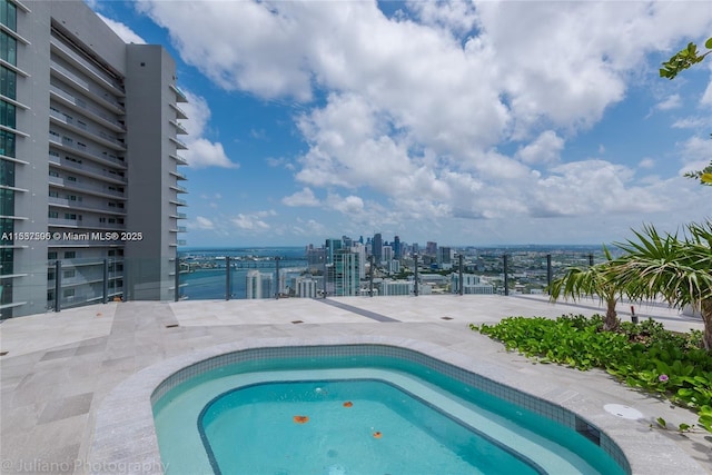 view of swimming pool with a hot tub and a city view