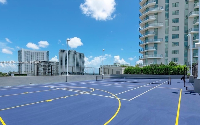 exterior space with community basketball court, fence, and a city view