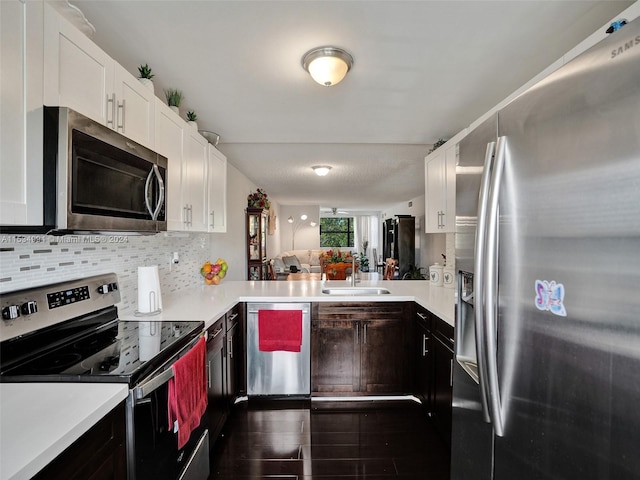 kitchen featuring sink, dark hardwood / wood-style flooring, white cabinets, appliances with stainless steel finishes, and backsplash